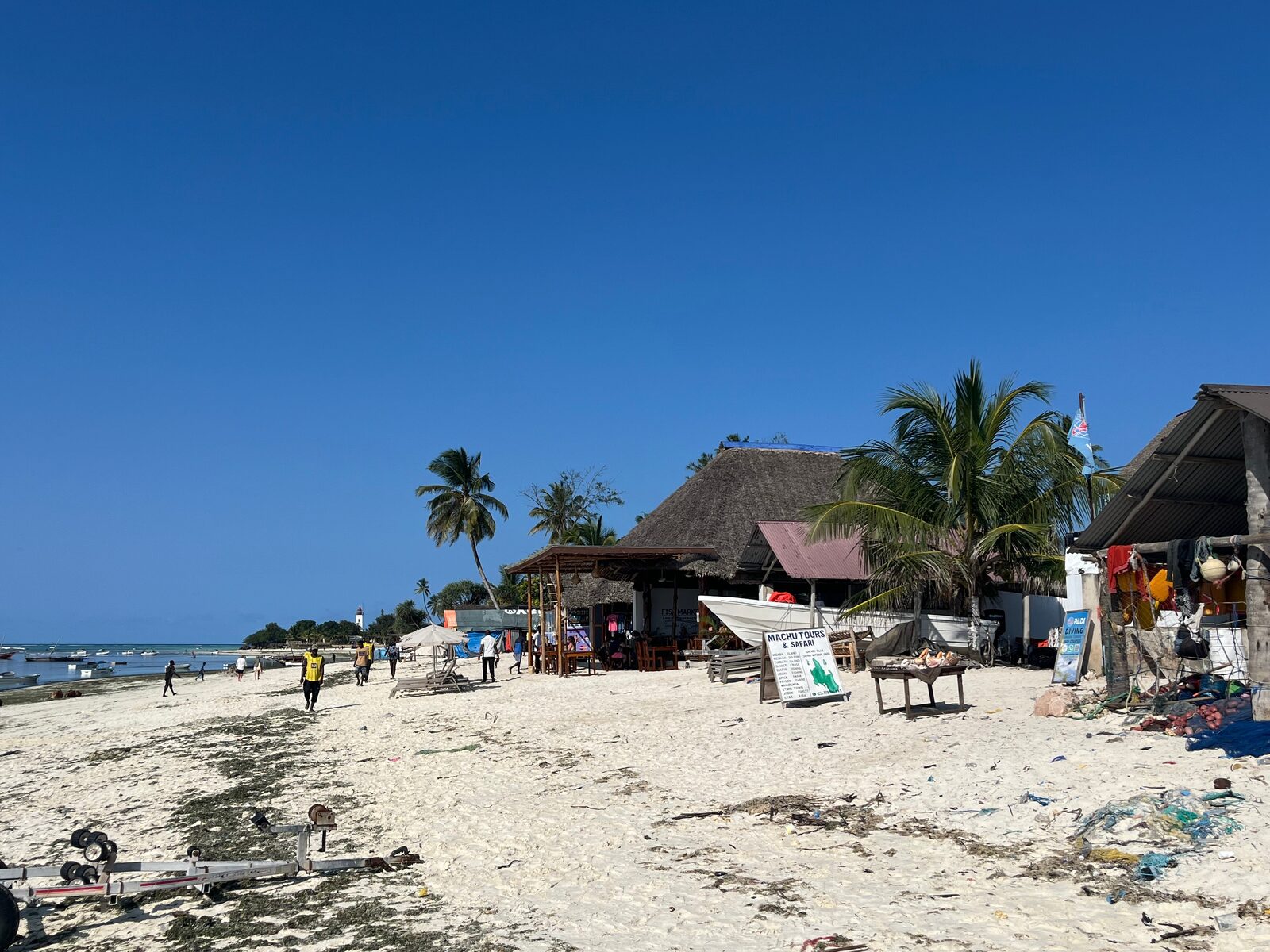 Village tour past beachside shops and boats in Zanzibar