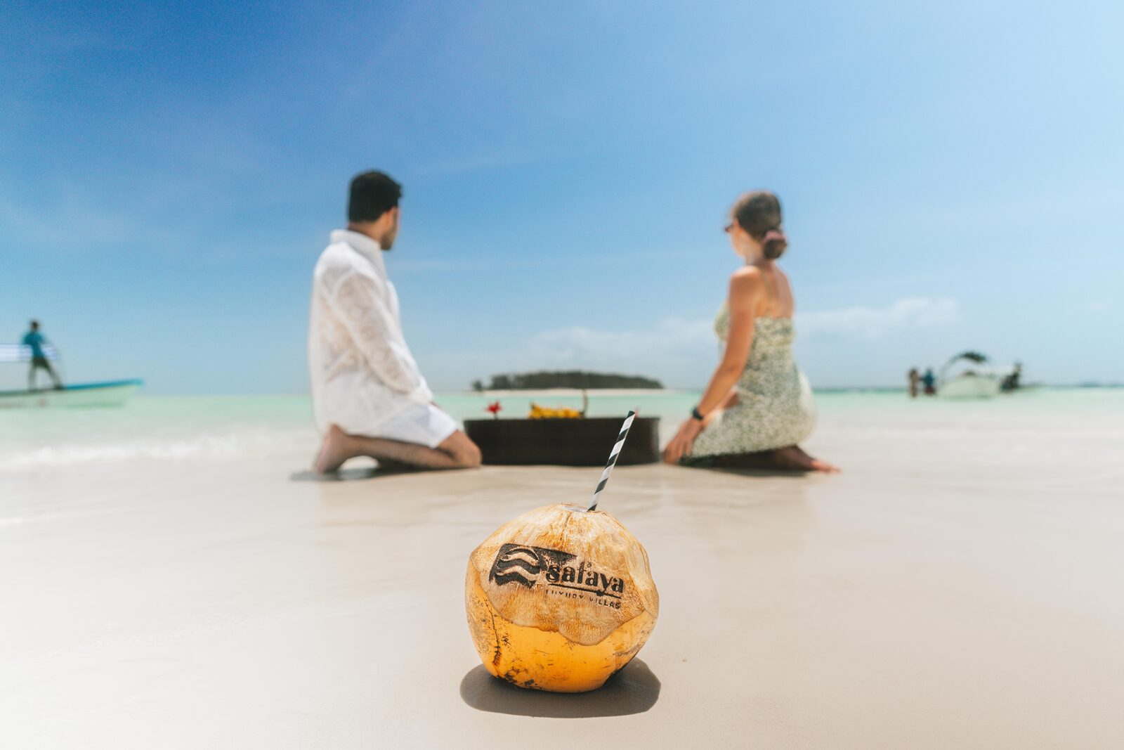Couple enjoying coconut drinks on a Zanzibar beach