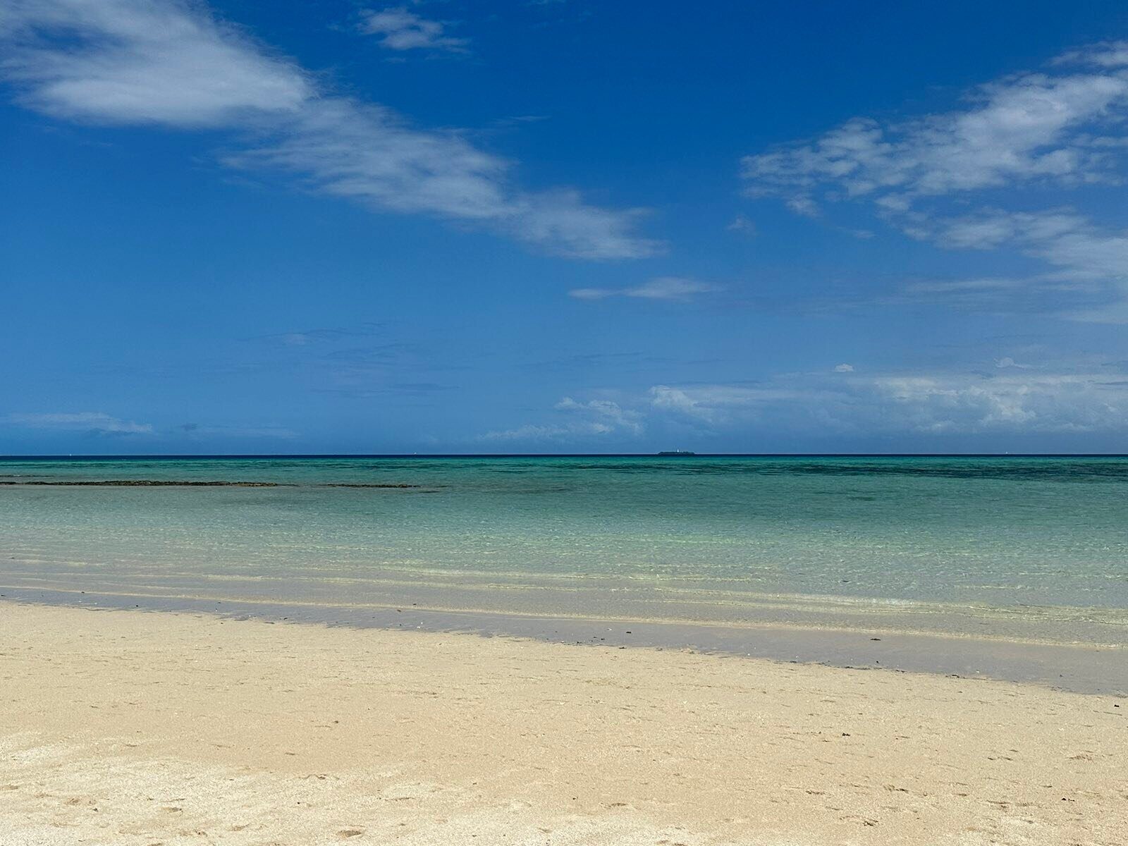 Calm turquoise sea meeting white sand on a Zanzibar beach