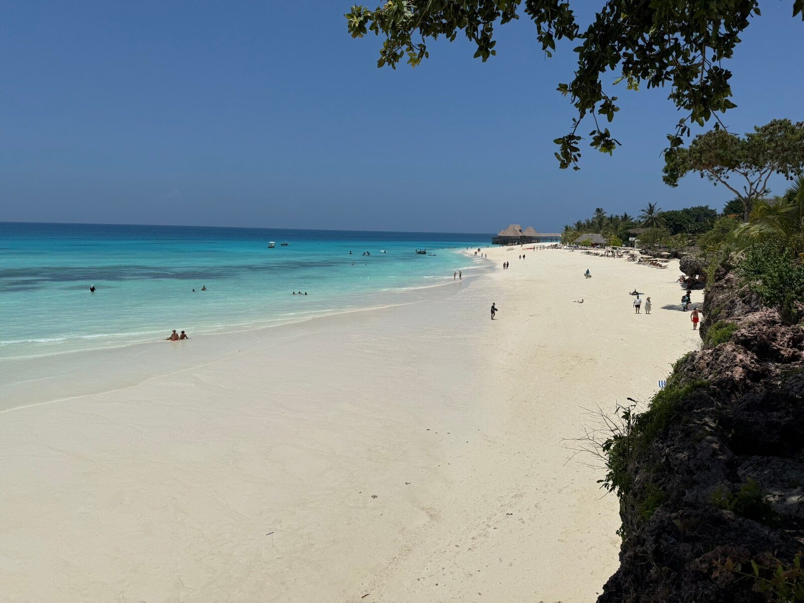 Clifftop view over a white beach and clear Zanzibar water