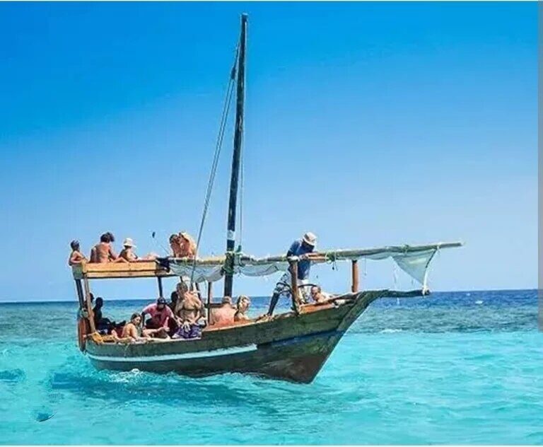 A dhow carrying snorkellers over turquoise water