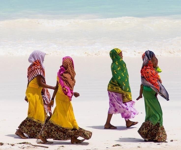 Women in colorful Zanzibari dresses walking together
