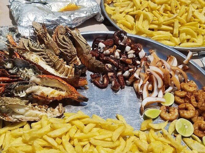 Grilled seafood platter with fries at a Zanzibar night market