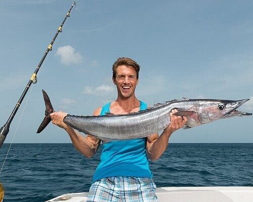 Angler holding a kingfish aboard a Zanzibar fishing boat