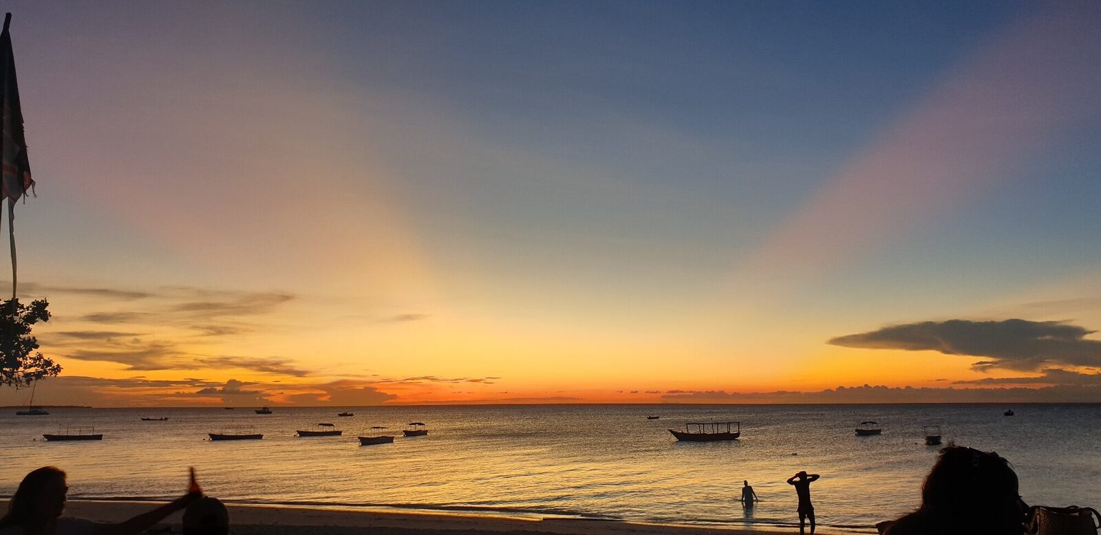 Panoramic sunset over a Zanzibar beach with boats