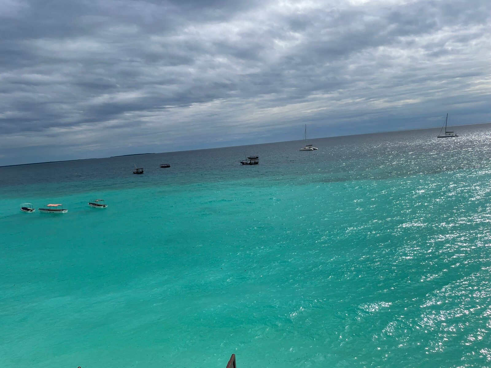 Anchored boats resting in a calm turquoise Zanzibar lagoon