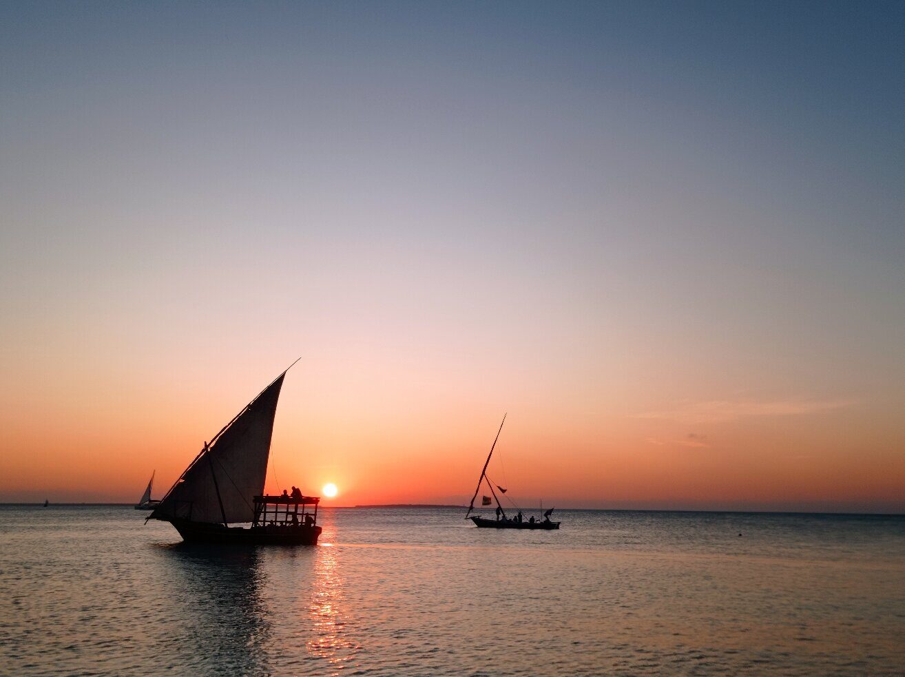 Two dhows silhouetted against a Zanzibar sunset