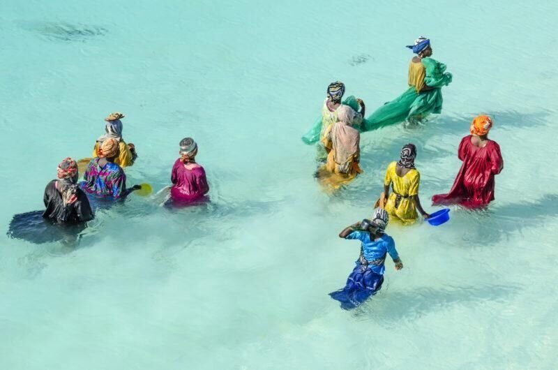 Women in colorful dresses by the Stone Town waterfront