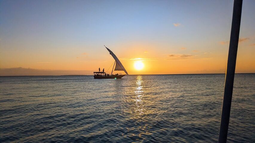 A dhow sailing at sunset off Zanzibar